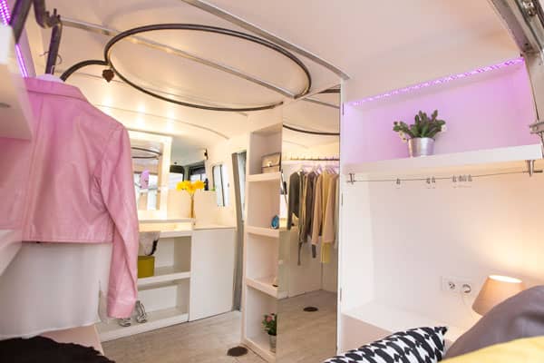 Intérieur aménagé du fashion truck — penderies circulaires et éclairage LED violet