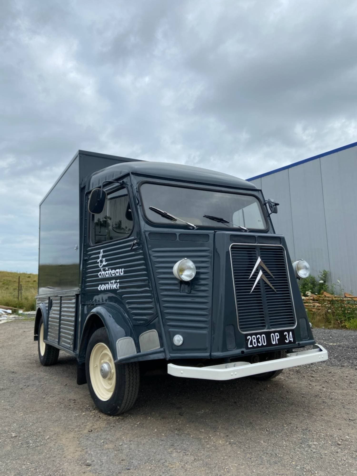 Vue avant Citroën Type H gris foncé Château Contiki avec chevrons Citroën, phares ronds et plaque 2830 QP 34