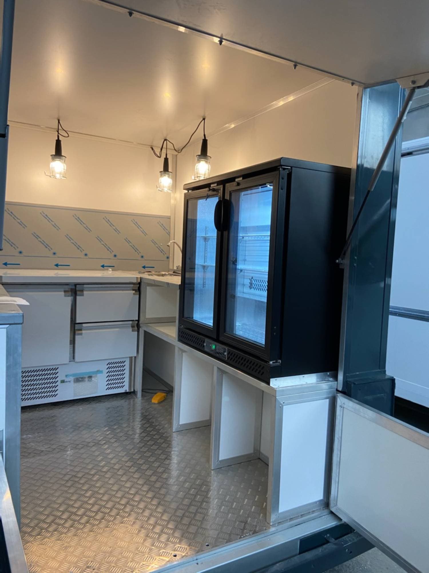 Aménagement intérieur Citroën Type H bar avec vitrine réfrigérée double porte, suspensions vintage et comptoir inox