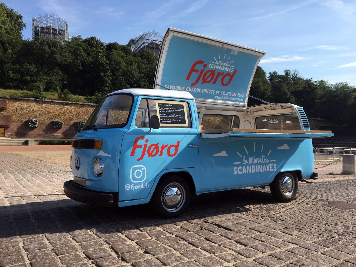 Combi VW pick-up bleu ciel Fjørd « Les Minutes Scandinaves » vu de face — activation de marque avec comptoir en bois