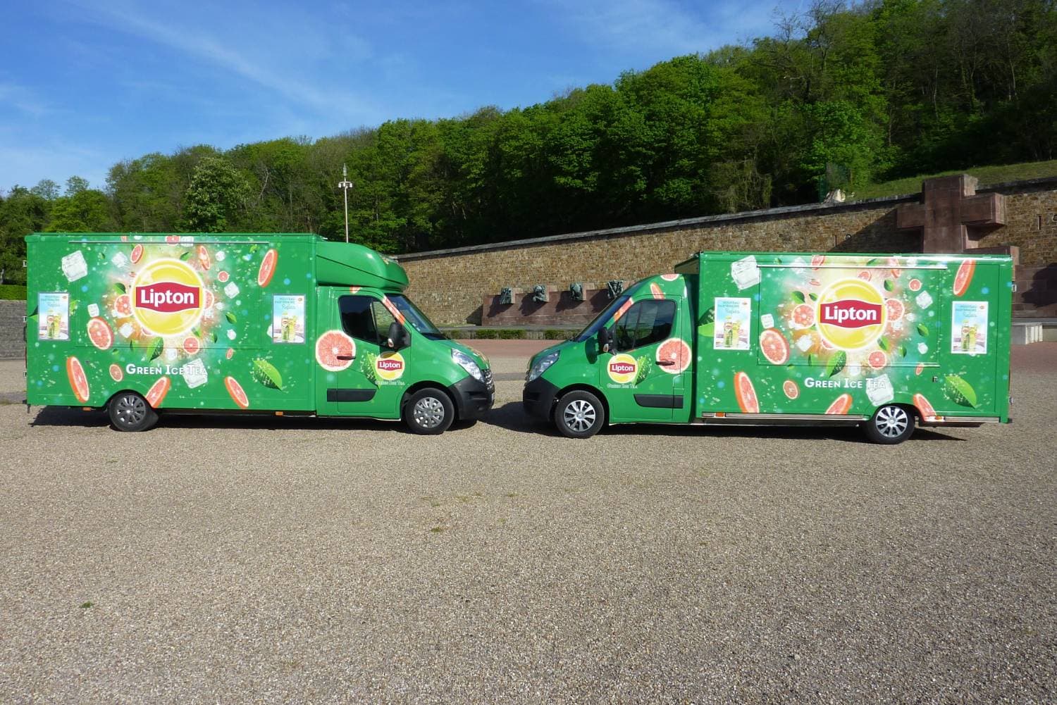 Duo de food trucks Lipton Green Ice Tea verts garés côte à côte avec covering assorti vue latérale