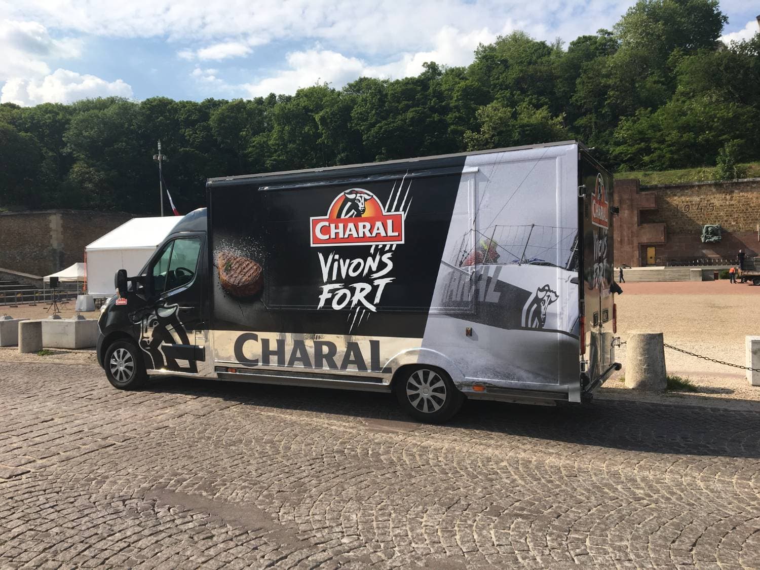 Vue latérale du Renault Master noir Charal Vivons Fort avec covering intégral et logo taureau