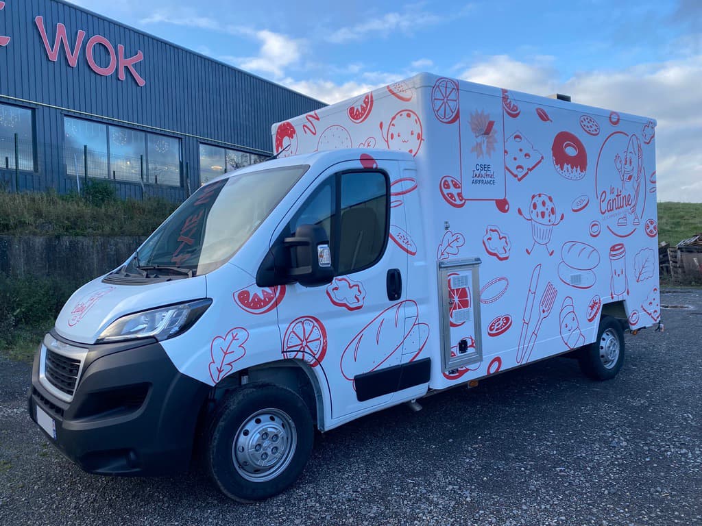 Food truck La Cantine Air France blanc avec illustrations rouges de pâtisseries et aliments stationné en extérieur