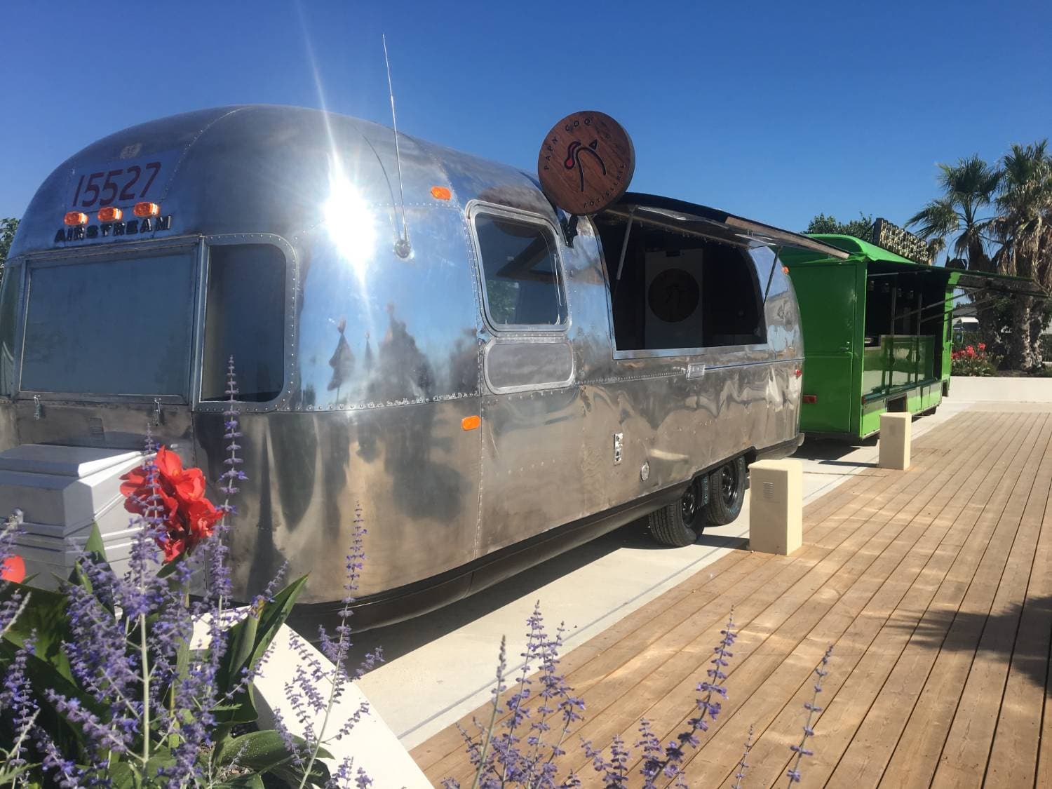 Airstream Papy Coq — vue latérale avec coque aluminium et enseigne ronde en bois