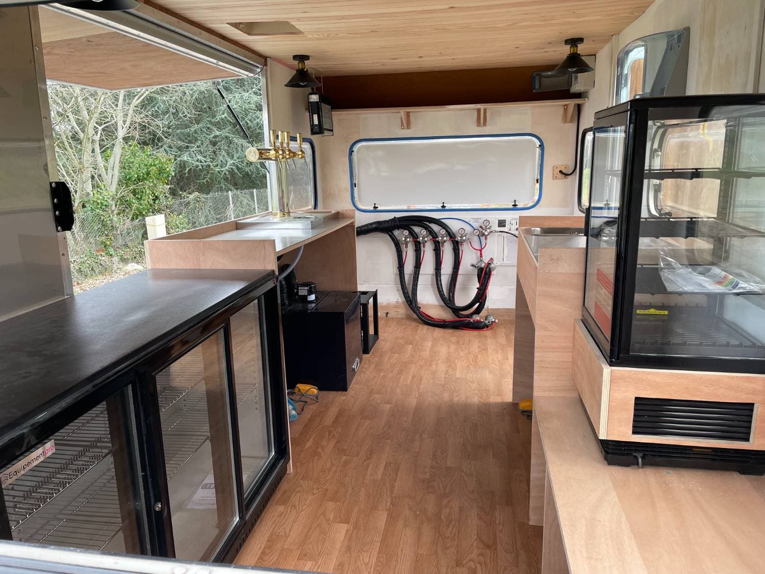 Vue extérieure de la caravane La Mignonnerie — volet latéral relevable et aménagement bar visible