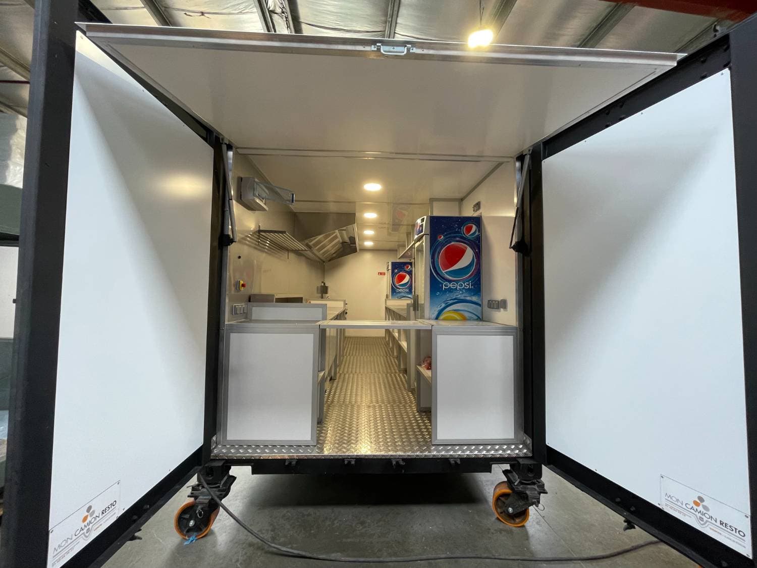 Vue arrière portes ouvertes — cuisine complète visible, logo Mon Camion Resto