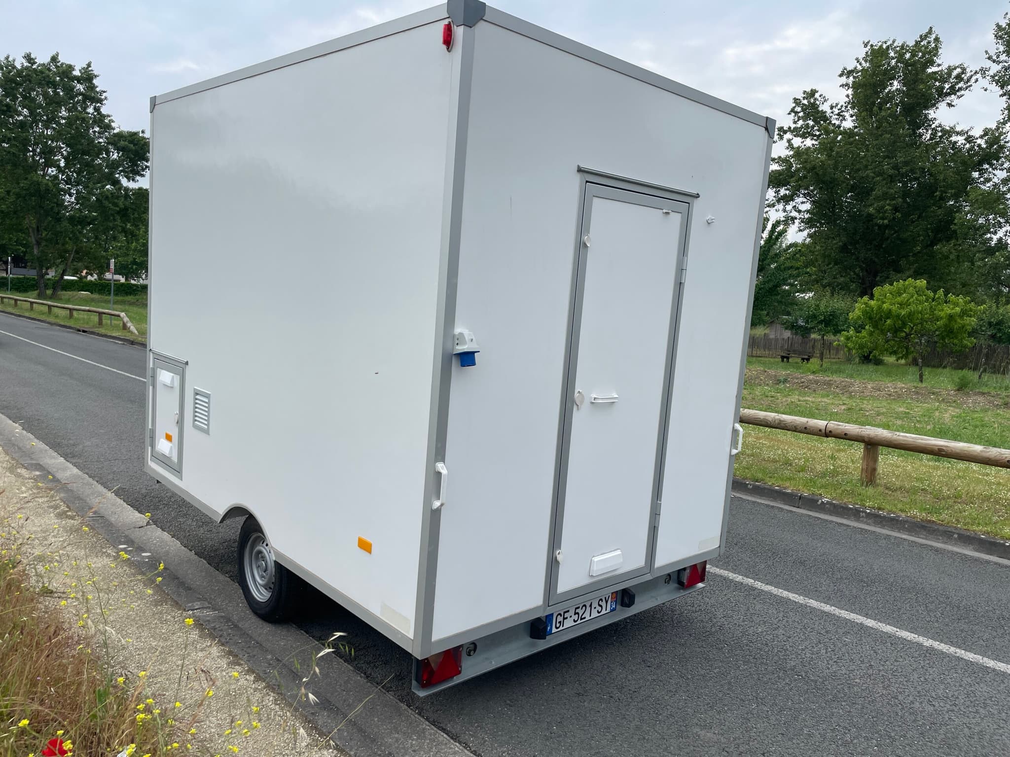 Vue arrière — porte d'accès, branchements électriques extérieurs et grille de ventilation