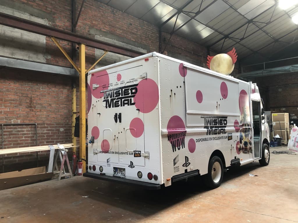 Step van Twisted Metal PlayStation blanc avec pois roses et tête de clown sur le toit vue arrière