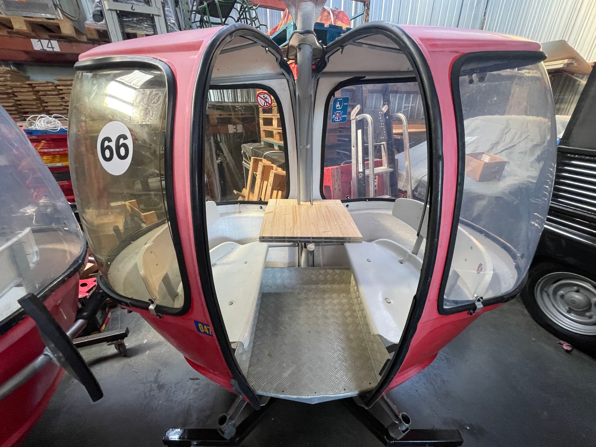 MEGG rouge n°66 — portes ouvertes sur la table en bois et banquettes