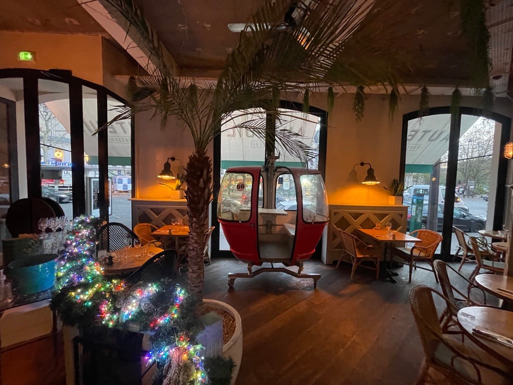 Ambiance du restaurant avec palmier, guirlandes lumineuses et mobilier en rotin