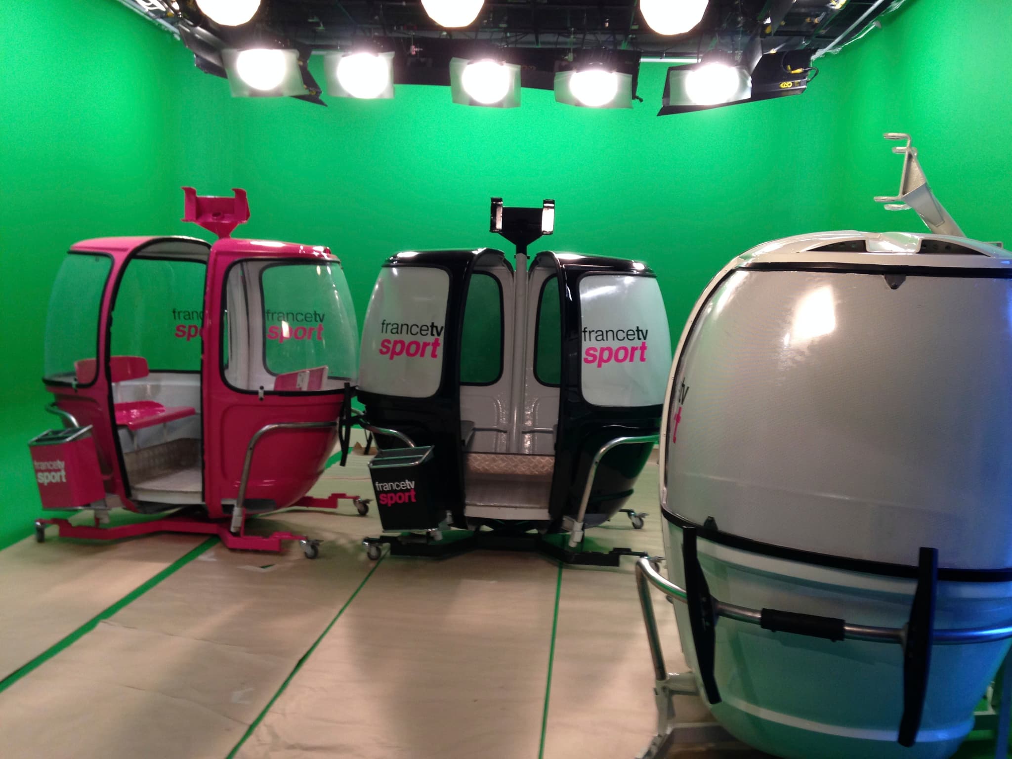 Plusieurs télécabines MEGG France TV Sport sur un plateau de tournage fond vert
