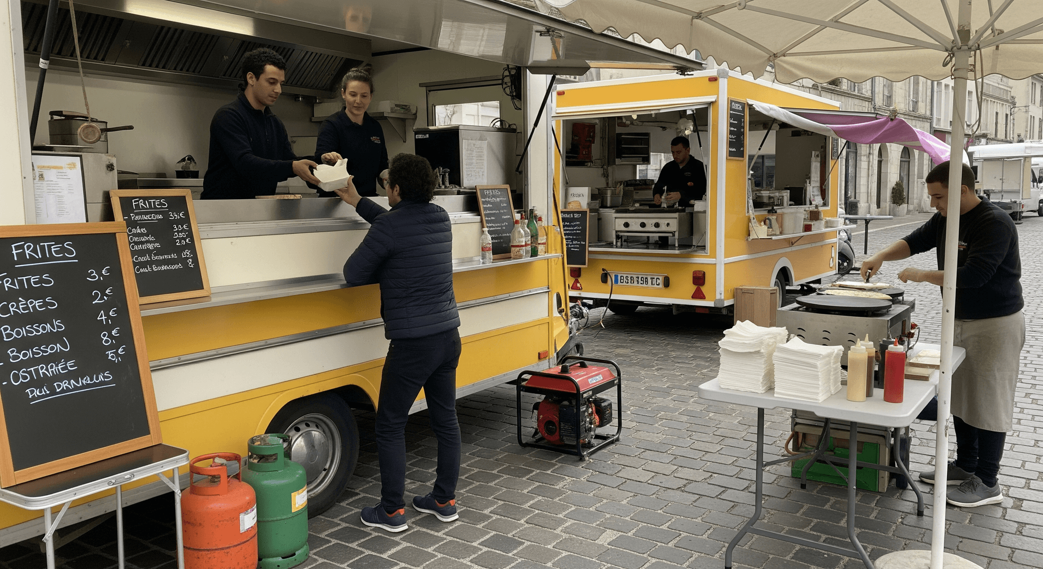Deux remorques food truck jaunes en service : clients servis et crêpes préparées lors d'un événement de restauration ambulante.