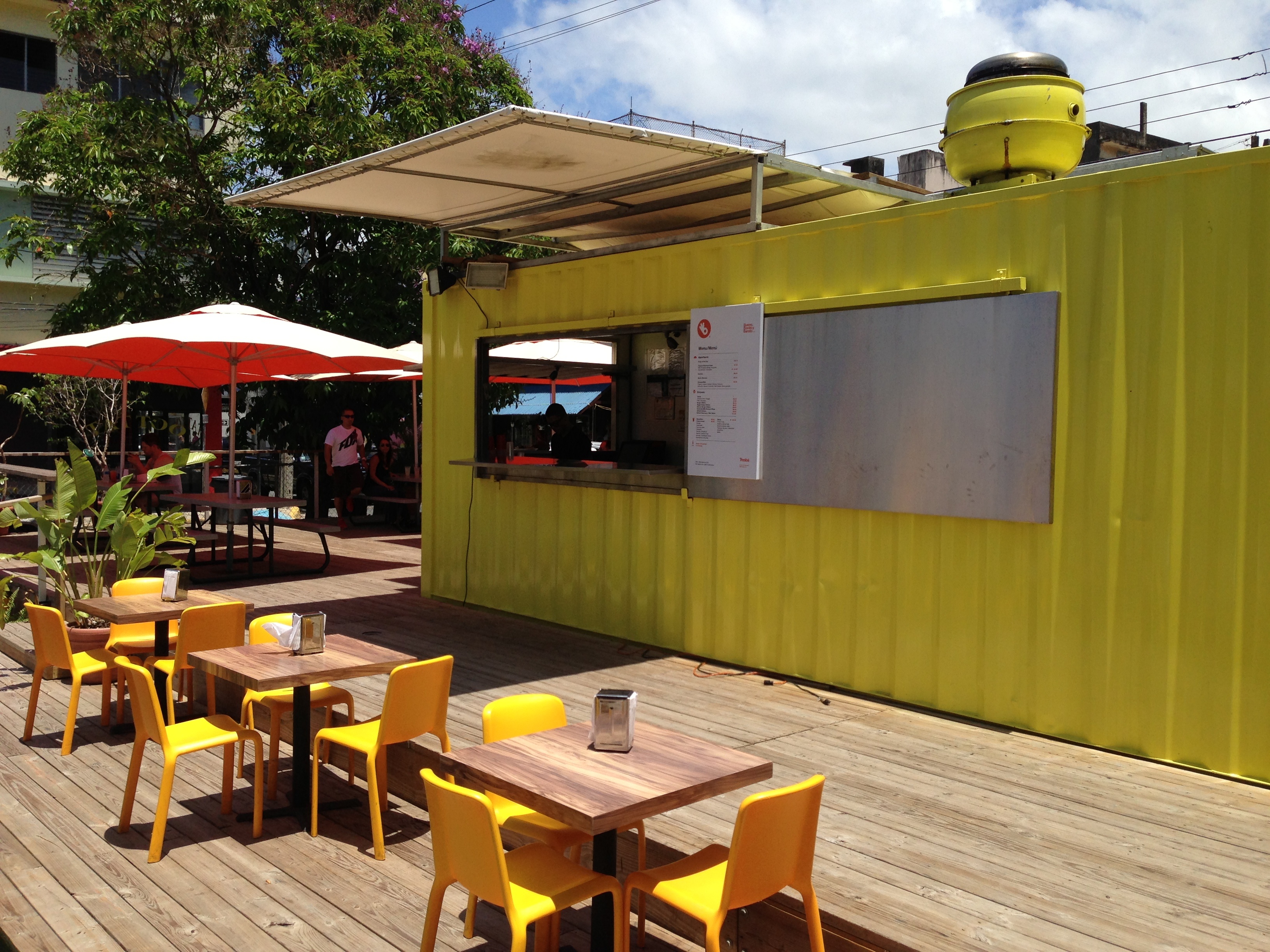 Container snack jaune avec terrasse restaurant en extérieur et mobilier intégré