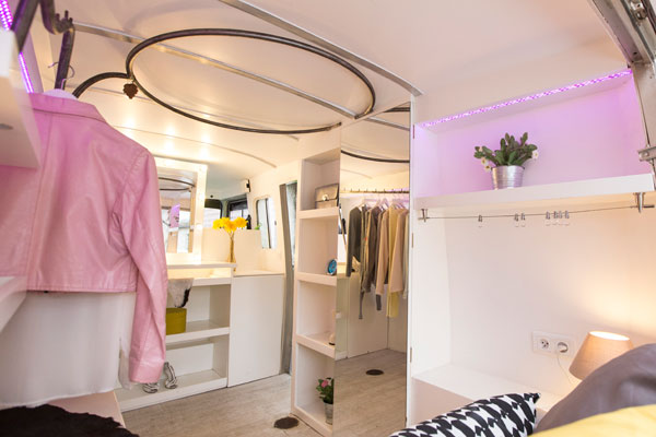 Intérieur aménagé du fashion truck — penderies circulaires et éclairage LED violet
