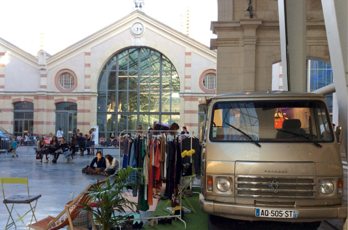 Fashion truck Peugeot J9 devant une gare — portants et vêtements en extérieur